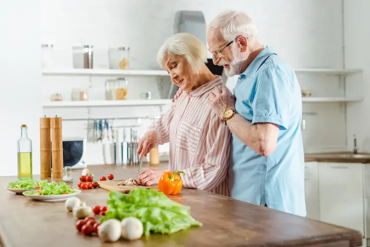 senior couple chopping vegetables in a kitchen