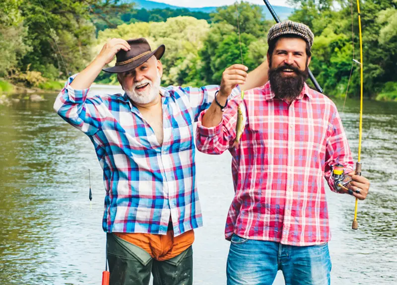 a father and son with a fish and fishing poles