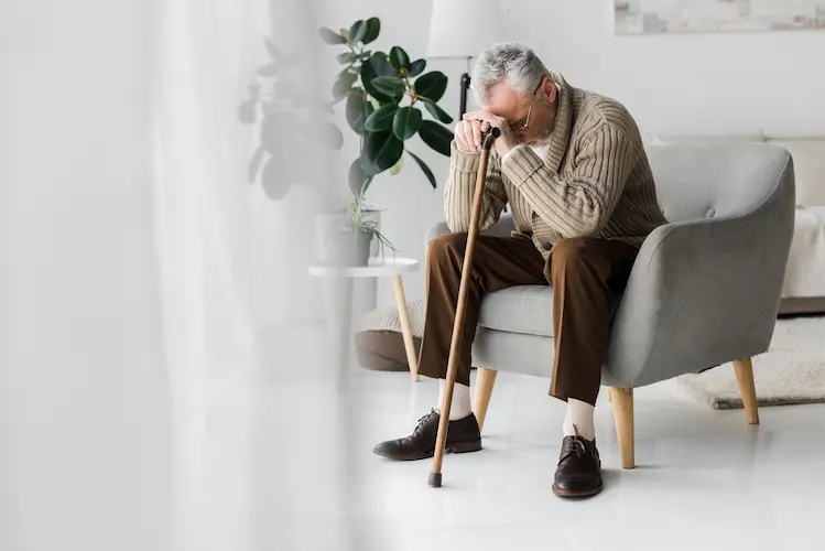 a man with a cane resting his head down