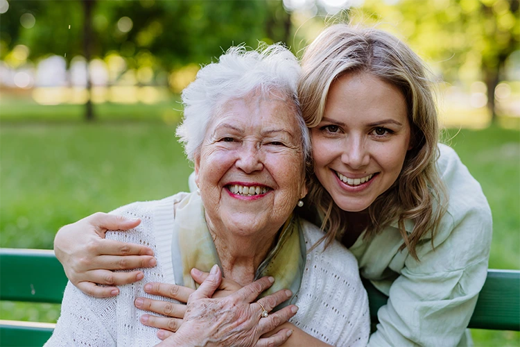 a young woman hugging an older woman from behind